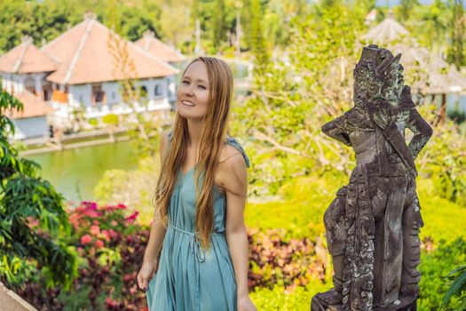 Young woman in dress in Water Palace Soekasada Taman Ujung Ruins on Bali Island in Indonesia. Amazing old architecture. Travel and holidays background.