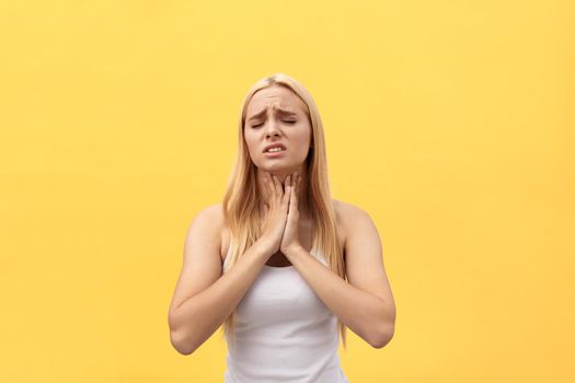 Tired young caucasian woman having pan in neck. Isolated over yellow background