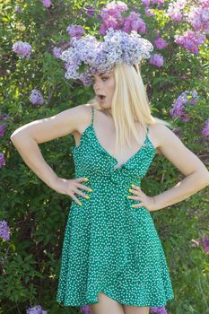 Beautiful woman in lilac Garden. Girl with lilac wreath in springtime. Gardening. Soft focus