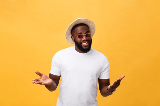 Portrait of handsome young african guy smiling in white t-shirt on yellow background.