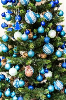 Beautiful New Year Tree Closed-Up. Green Christmas Tree Decorated with Blue and White Balls. Holiday Atmosphere. Winter Season Mood.