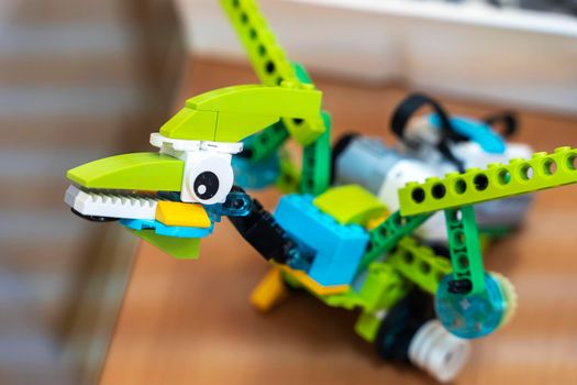 a programmable children's robot in the form of a pterodactyl assembled from designer parts. A computer-controlled dinosaur robot, a modern toy. Educational technologies. education. code and programming.