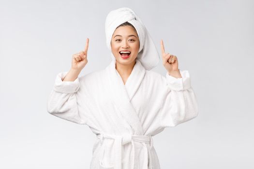 Beauty portrait of young woman showing and pointing finger to empty copy space, asian beauty in bathrobe