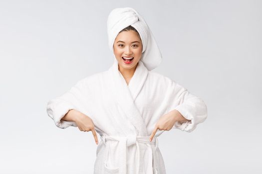 Beauty portrait of young woman showing and pointing finger to empty copy space, asian beauty in bathrobe