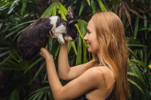 Woman holding a rabbit. Cosmetics test on rabbit animal. Cruelty free and stop animal abuse concept.