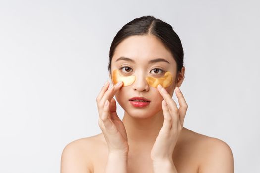 Asian beauty teenager woman care her skin with gold eye masks patches under eyes.