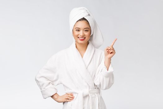 Beauty portrait of young woman showing and pointing finger to empty copy space, asian beauty in bathrobe