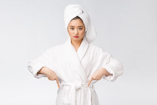 Young beautiful woman wearing shower towel after bath over isolated white background pointing with finger