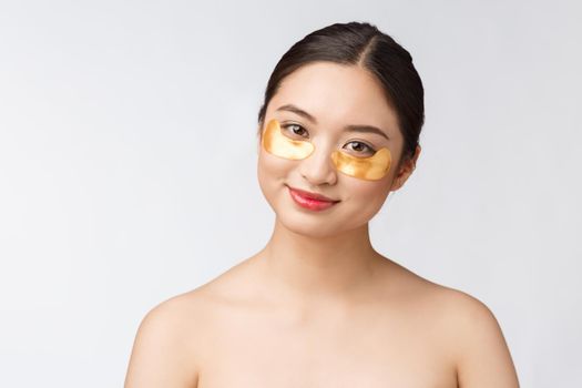 Asian beauty teenager woman care her skin with gold eye masks patches under eyes.