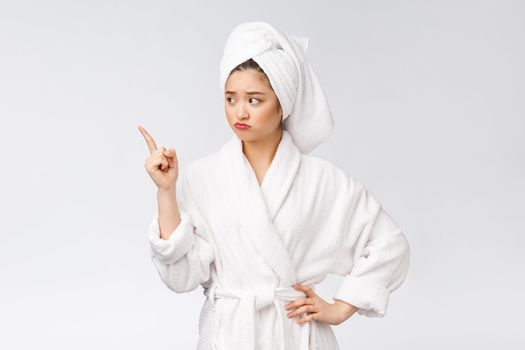 Young beautiful woman wearing shower towel after bath over isolated white background pointing with finger