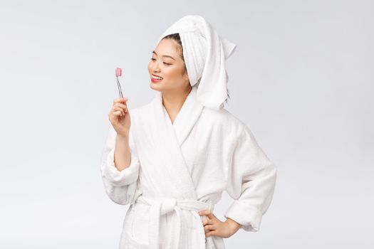 Asian happy woman with toothbrush in bathrobe morning mood.