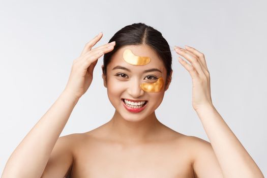 Asian beauty teenager woman care her skin with gold eye masks patches under eyes.