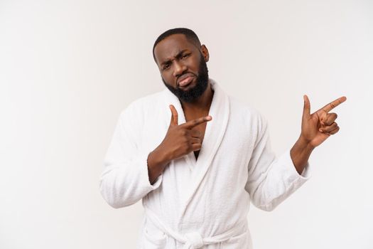 Black guy wearing a bathrobe pointing finger with surprise and happy emotion. Isolated over whtie background