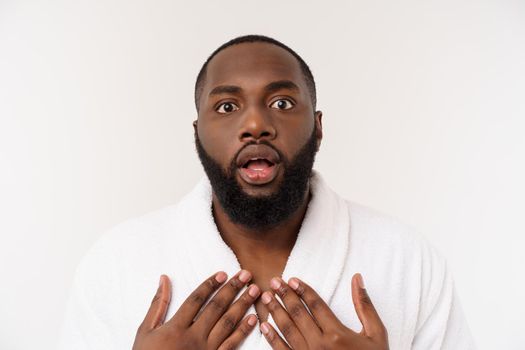 Black guy wearing a bathrobe pointing finger with surprise and happy emotion. Isolated over whtie background