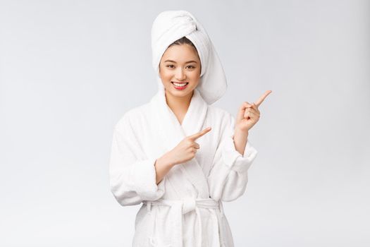 Beauty portrait of young woman showing and pointing finger to empty copy space, asian beauty in bathrobe