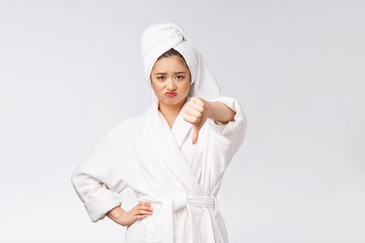 Beauty portrait asian woman looking on camera showing thumb down isolated over white background copy space