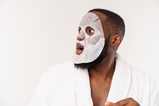 A young man with paper mask on face looking shocked with an open mouth, isolated on a white background