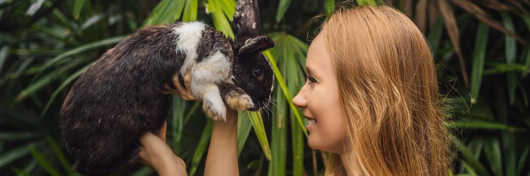 Woman holding a rabbit. Cosmetics test on rabbit animal. Cruelty free and stop animal abuse concept. BANNER, LONG FORMAT