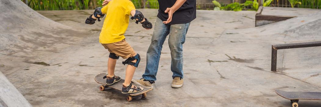 Athletic boy learns to skateboard with a trainer in a skate park. Children education, sports. BANNER, LONG FORMAT