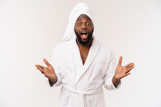 Black guy wearing a bathrobe pointing finger with surprise and happy emotion. Isolated over whtie background