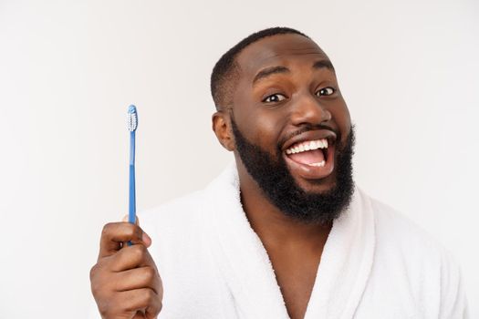 portrait of a happy young dark-anm brushing his teeth with black toothpaste on a white background