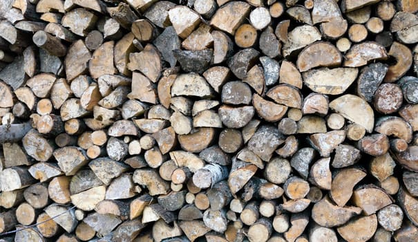 Large rural stack of firewood. Old firewood. Background.