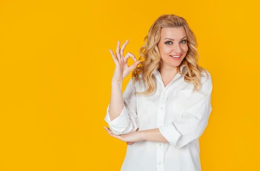 Charismatic self-confident cheerful, gorgeous adult woman, dressed in a white shirt, winking flirtatious sassy, smiling broadly, showing good, good, gesture, good mood, providing everything amazing