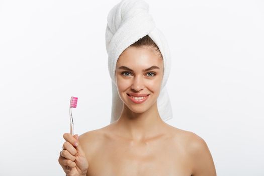 Smiling woman brushing her teeth with towel on her head. A great smile.