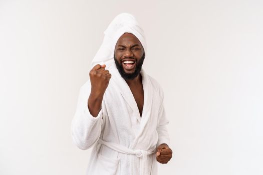 Black guy wearing a bathrobe pointing finger with surprise and happy emotion. Isolated over whtie background