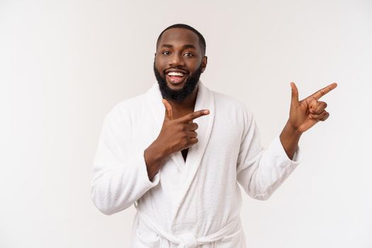 Black guy wearing a bathrobe pointing finger with surprise and happy emotion. Isolated over whtie background