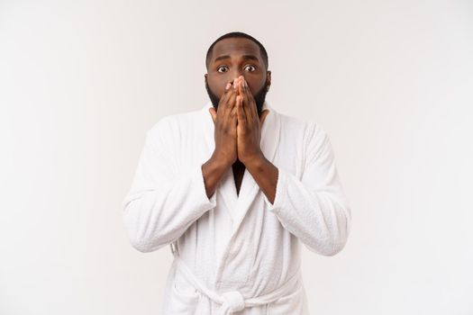 Black guy wearing a bathrobe pointing finger with surprise and happy emotion. Isolated over whtie background