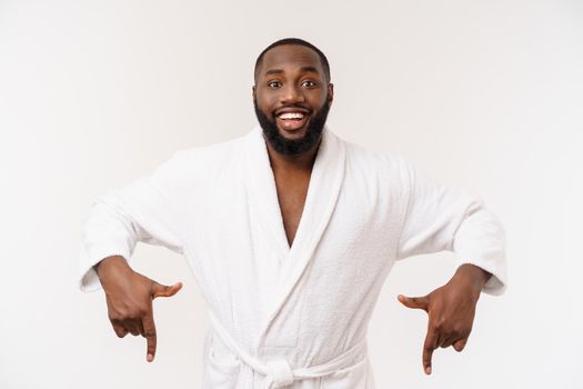 Black guy wearing a bathrobe pointing finger with surprise and happy emotion. Isolated over whtie background
