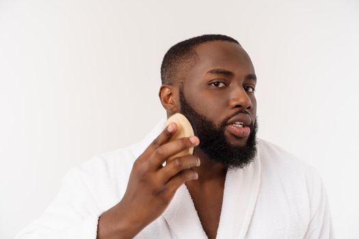 Smiling african man apply cleansing his face. Man's skin care concept.