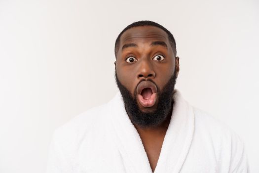 African American man wearing a bathrobe with surprise and happy emotion. Isolated over whtie background.