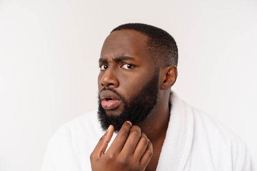 African American man wearing a bathrobe with surprise and happy emotion. Isolated over whtie background.