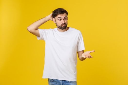 Worried young man standing isolate on yellow wall.