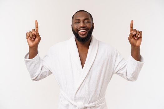 Black guy wearing a bathrobe pointing finger with surprise and happy emotion. Isolated over whtie background