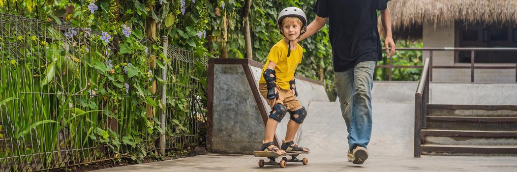 Athletic boy learns to skateboard with a trainer in a skate park. Children education, sports. BANNER, LONG FORMAT