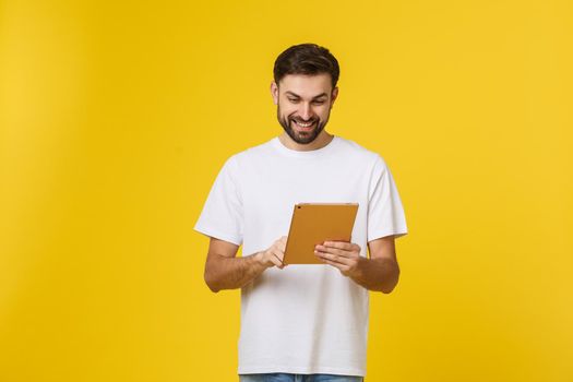 Attractive fashionable young Caucasian man working on touch pad pc, making presentation, using wireless high speed internet connection