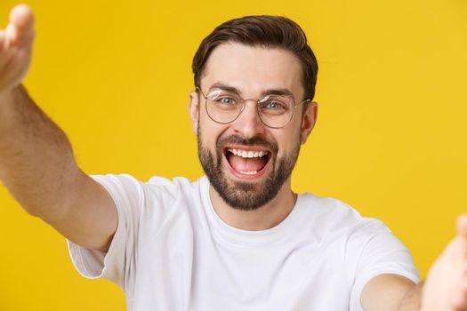 Close up portrait of a cheerful bearded man taking selfie over white background
