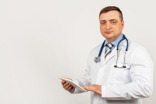 Portrait of a male doctor using a digital tablet. Doctor using a tablet and checks the analysis on a virtual interface. Medicine. Medical science and biotechnology.