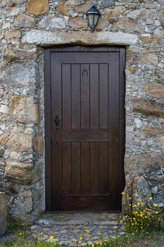 Ancient wooden door in stone wall.