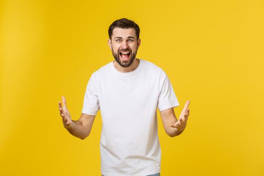 Portrait unhappy handsome man looking at camera on yellow background