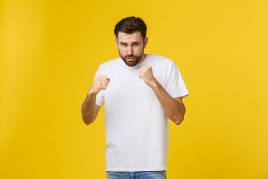 Young blond curly hair caucasian man isolated throwing a punch, anger, fighting due to an argument, boxing.