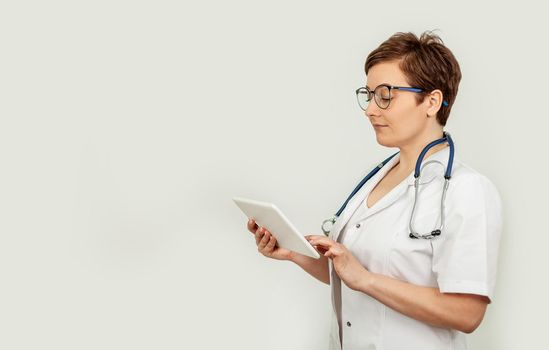 Portrait of a female doctor using her digital tablet. Female doctor using tablet and checking with analysis on a virtual interface. Medicine. Medical science and biotechnology.