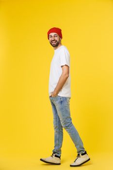 young hipster man wearing hat , suspenders, isolate on yellow background