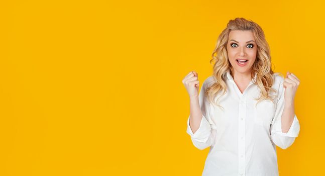 The concept of tension, games and emotions. An encouraged, excited pretty woman in a white shirt, rooting for the team, made a big bet and screamed, come on TV, clenched fists and screaming,