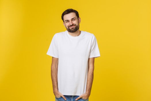 Portrait of a handsome young man smiling against yellow background.