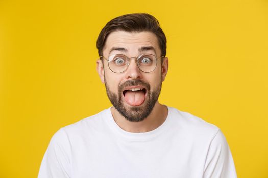 Young man looking at copyspace having a surprised or satisfied look isolated on yellow background