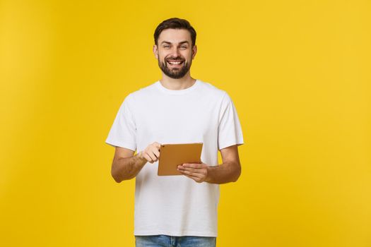 Attractive fashionable young Caucasian man working on touch pad pc, making presentation, using wireless high speed internet connection